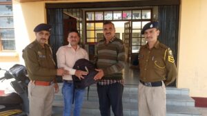 थाना पच्छाद में देवेन्द्र दत्त शर्मा राजेश चौहान को बैग देते हुए